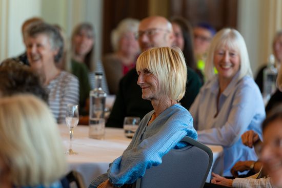 Group of volunteers sat around a table waiting at event