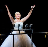 Woman dressed in white dress holding hands up to the sky