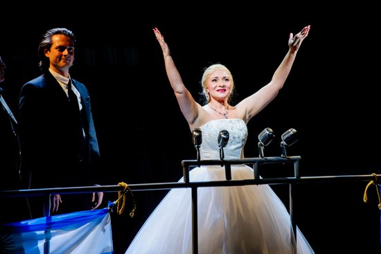 Woman dressed in white dress holding hands up to the sky