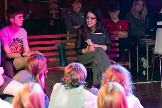 Young people sat listening to staff member