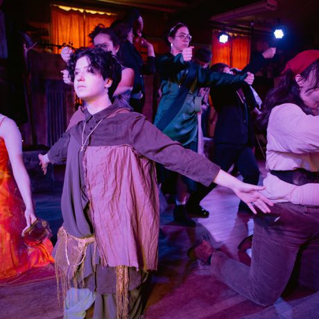 Performers on knees holding arms out to either side