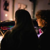 Silhouette of two young people sat behind tech desk