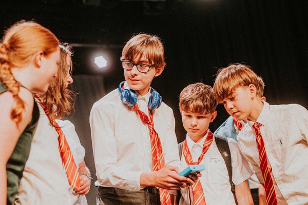 Close up of young people performing dressed in school uniform