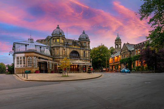A beautiful old building with a pink and purple sunset above.