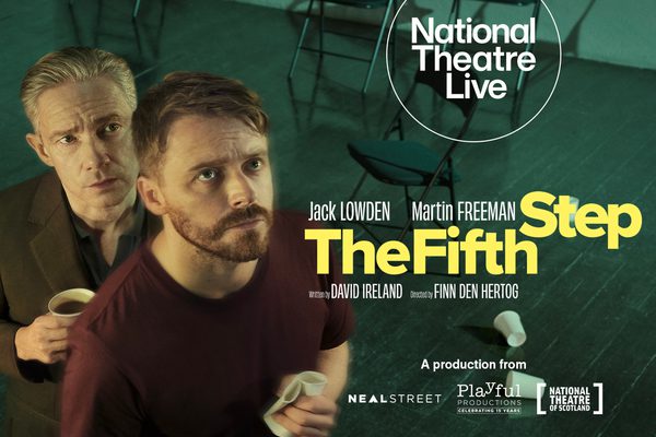 Jack Lowden and Martin Freeman looking up, in a room with folding chairs and a wooden floor.