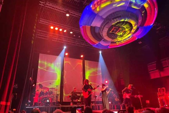 A large inflatable ELO Show logo floating above an audience.