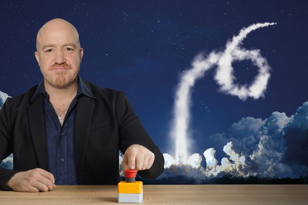 Andy Parsons pressing a red button that triggers an explosion.