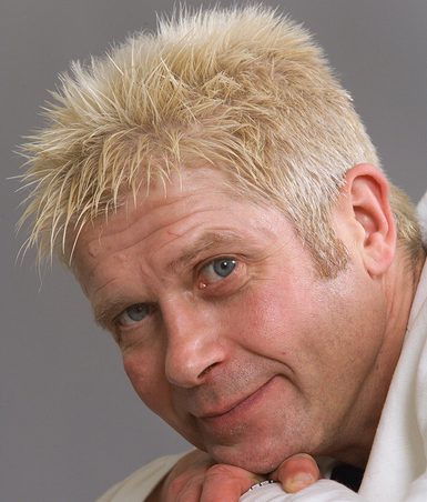 A man with blonde spiky hair looking at the camera.