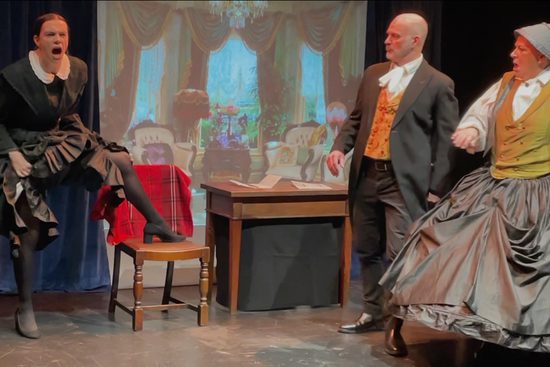 A woman dressed in black angrily putting one foot on a wooden chair.