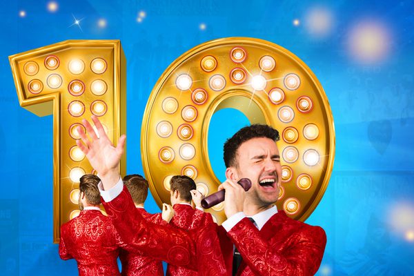 Four men in red jackets singing in front of a big yellow number 10.