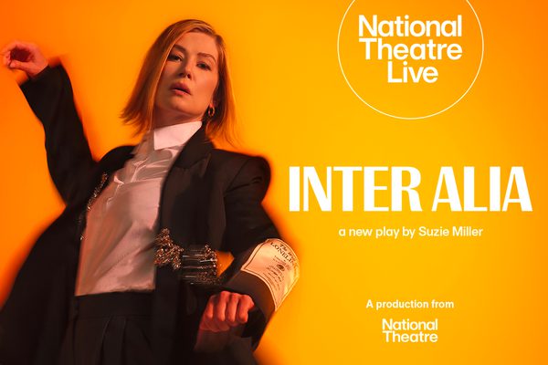 Rosamund Pike dancing in a shirt and suit jacket. She looks tired or drowsy