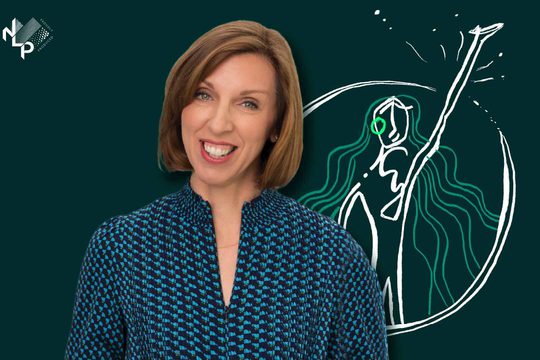 A woman with brown shoulder length hair and a big smile.