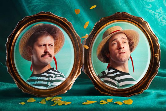 Two picture frames with pictures of men in straw hats and stripy tops. The background is a deep teal curtain.