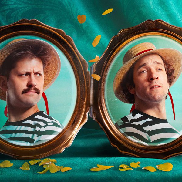 Two picture frames with pictures of men in straw hats and stripy tops. The background is a deep teal curtain.