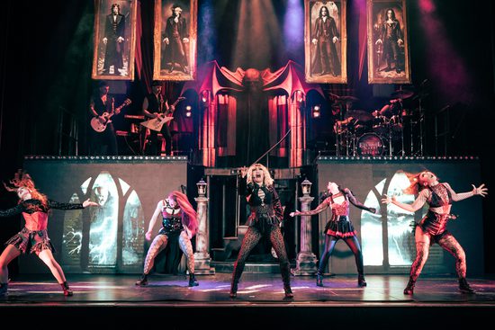 Women dancing underneath portraits of vampires.