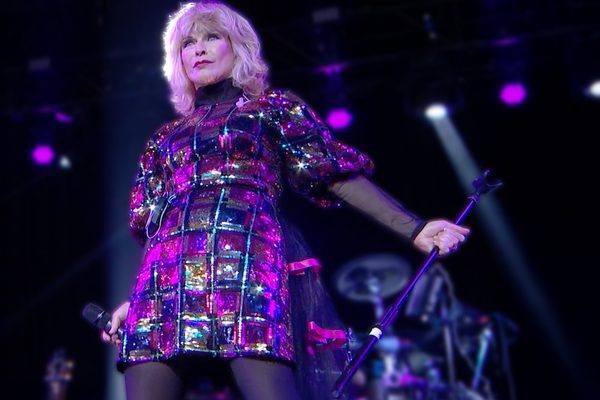 Toyah in a purple sparkly dress holding a microphone stand.