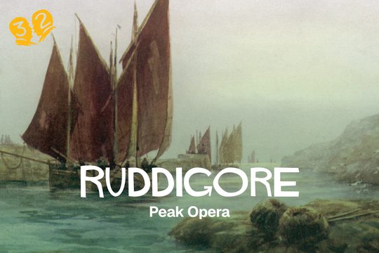 A ship with large red sails in a bay.