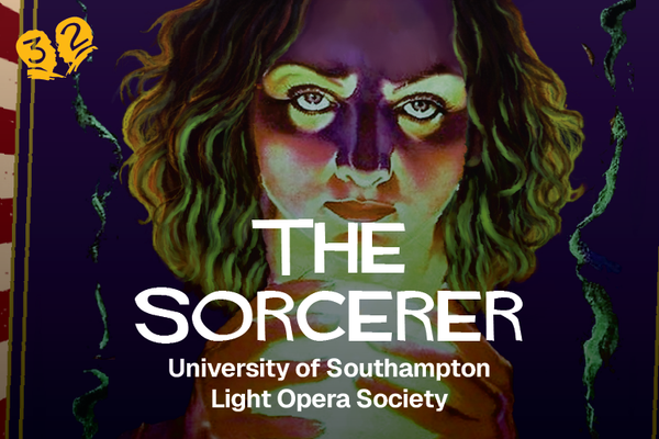 A woman with shoulder-length curly hair lit by a glowing orb. She has a menacing look on her face.