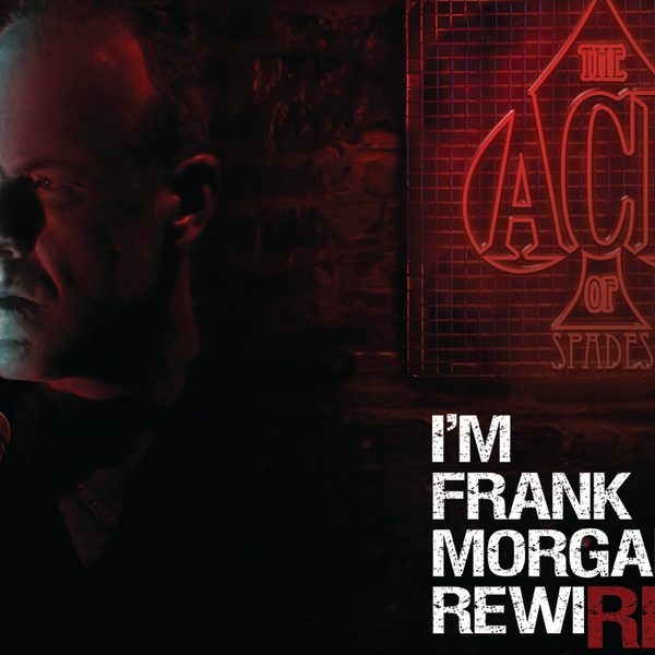 A man looking to one side with a serious expression, next to a red sign that says "The Ace of Spaces".