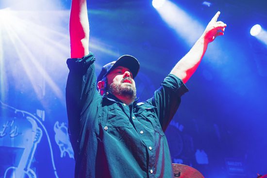 performer holds both hands up in the sky in front of audience