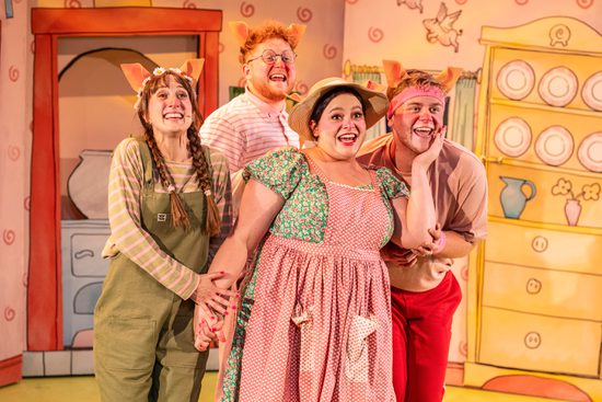 A group of four people. They are all wearing colourful costumes with various prints, and pig ears on their heads.