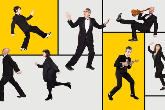 Seven memebers all stand in crazy poses on a white and yellow art deco background