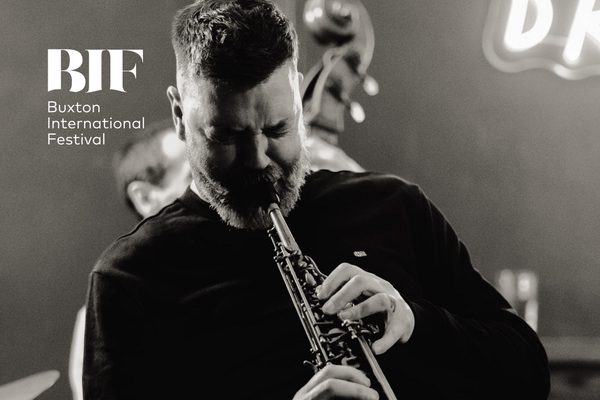 Black and white image of a man playing a saxophone.