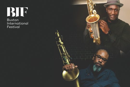 Two men looking straight at the camera, holding saxophones.