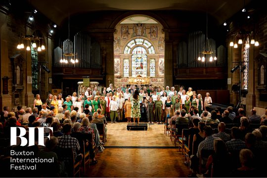 A choir of people dressed in bright colours performing in a church.