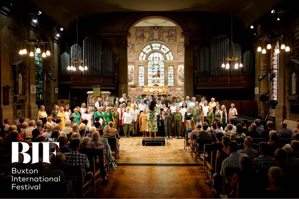 A choir of people dressed in bright colours performing in a church.