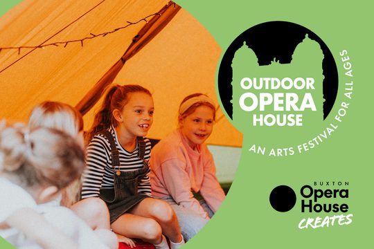 Children sat on the floor of a tent, smiling.