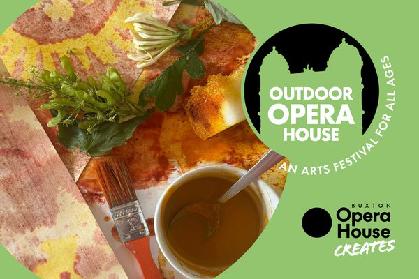 A table stained with orange paint with leaves and a paintbrush. Outdoor Opera House logo. Buxton Opera House Creates logo.