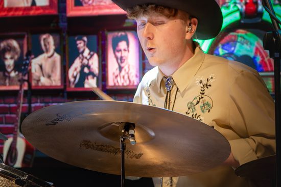 Close up of a drummer wearing a cowboy hat.