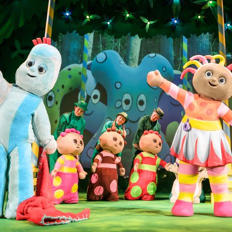 All of the characters stand on a colourful stage and dance together.