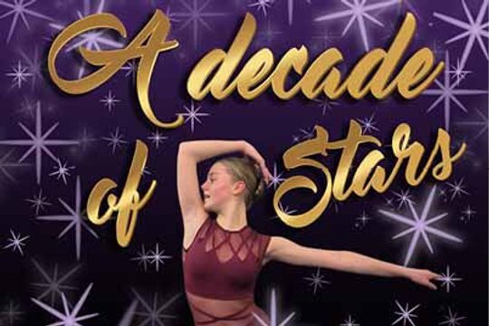 A girl in a maroon leotard dancing in front of a purple background.