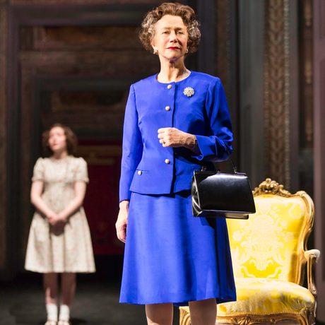 A woman in a vibrant blue suit looks straight out into the audience.