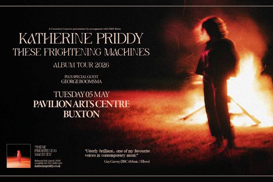 A woman standing in front of a bonfire.