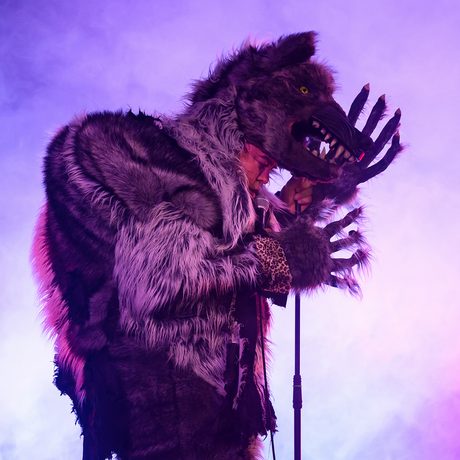 A man dressed as a wolf with his hand to his head.