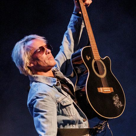 Jon Bon Joi Tribute holds up his guitar