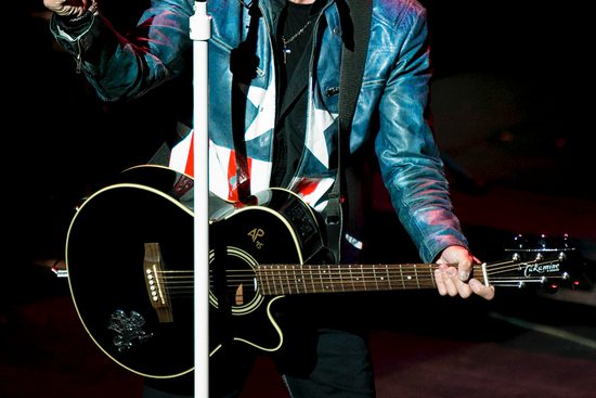 Bon Jovi tribute sings into microphone wearing a captain America jacket