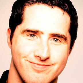 A white, brunette man smiles at the camera.