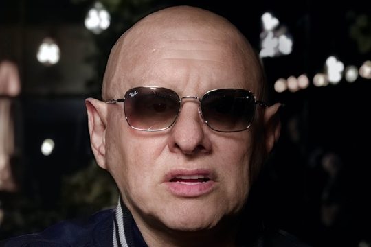 Close up of Shaun Ryder wearing sunglasses.