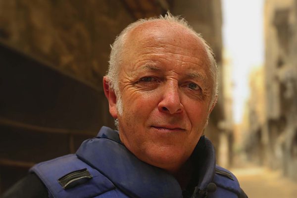 A man with grey hair looking straight at the camera.