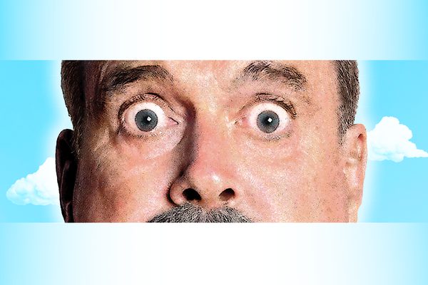A close-up of an older man's eyes and nose against a blue sky background.