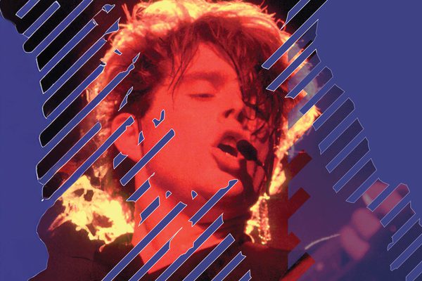 a man with a red hue over his face singing.