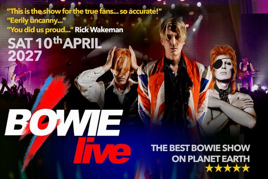 Three performers - one wearing a black waistcoat and white shirt, one wearing a red, white, and blue coat, and one wearing an eye patch.