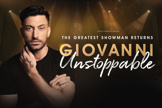 Giovanni: A man with dark hair and beard is wearing a black t-shirt and looks to the camera.
