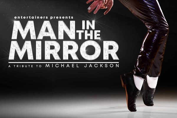 Two feet standing on tiptoes. White writing: Man in the Mirror.