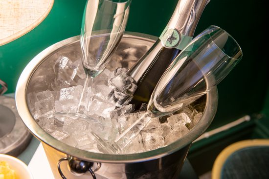 Bottle of fizz in an ice bucket, alongside 2 glasses