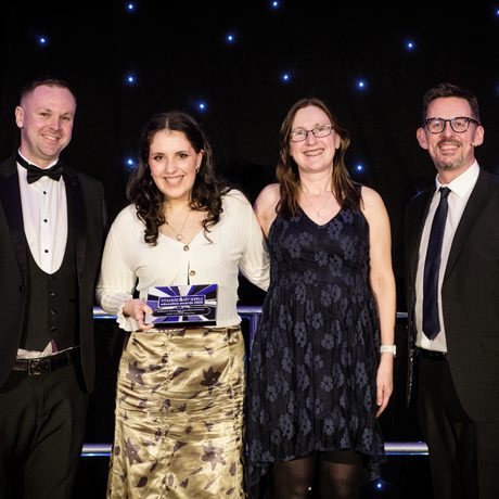 4 people pose with an award